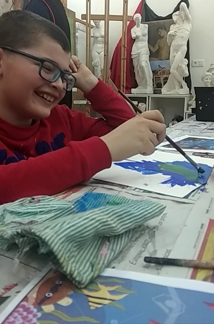 Sebastián pintando sonriente y feliz